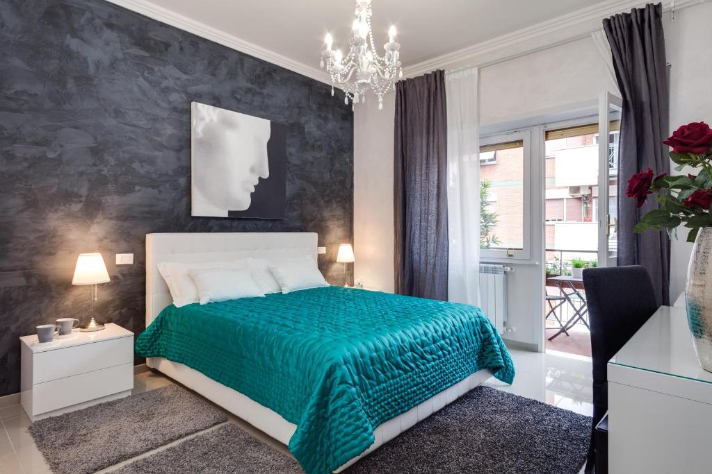 Dreamsrome Suites في روما: غرفة نوم بسرير وبطانية خضراء