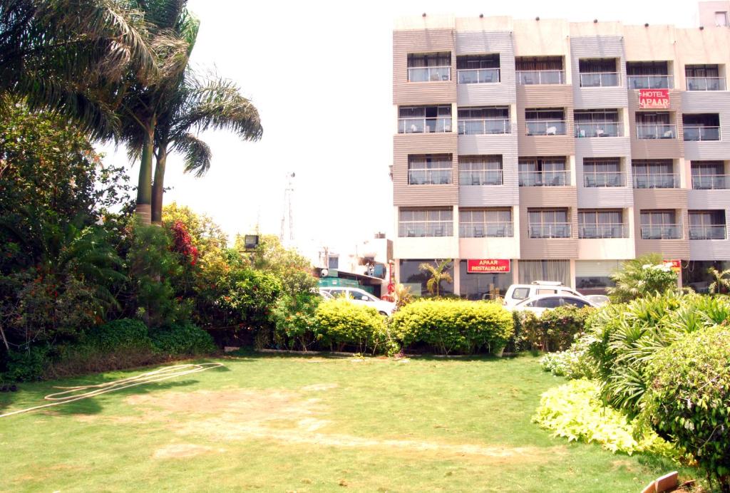 a lawn in front of a building with a building at Hotel Apaar in Diu