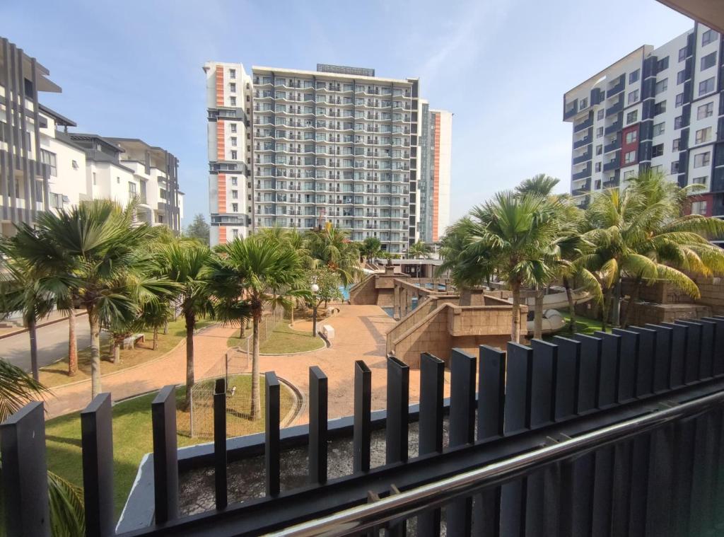 a balcony with palm trees and a tall building at Eqino Swiss Garden Studio with Pool View in Kuantan