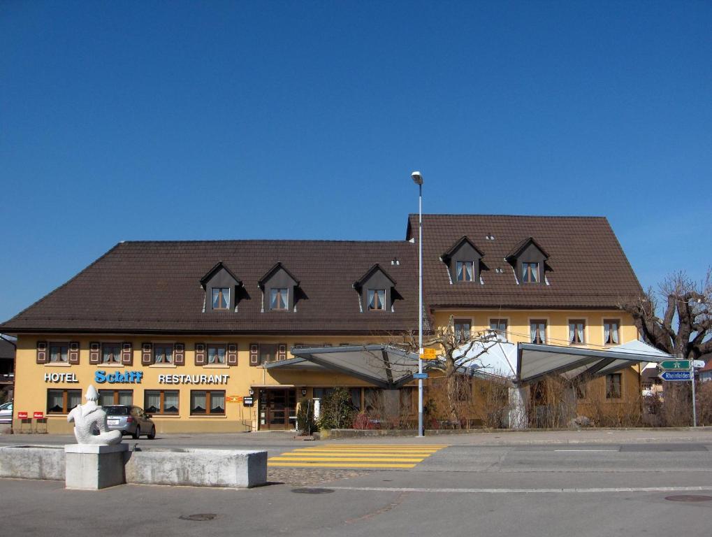 ein großes Gebäude mit einer Statue davor in der Unterkunft Hotel Restaurant Schiff in Möhlin
