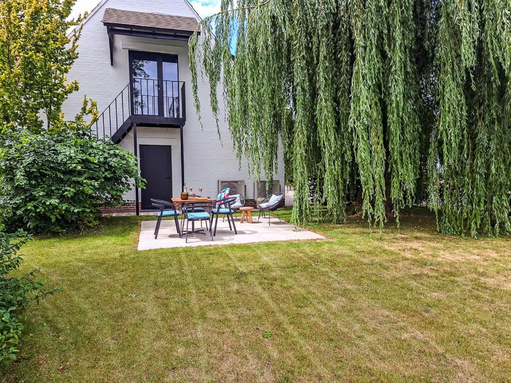 a patio with a table and chairs in a yard at Cosy apartment with garden in Kortrijk