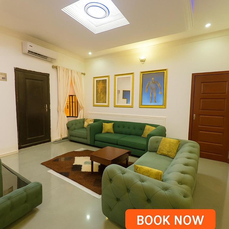 a living room with a green couch and a table at Essential Comfort Haven Homez in Ago Palace in Lagos