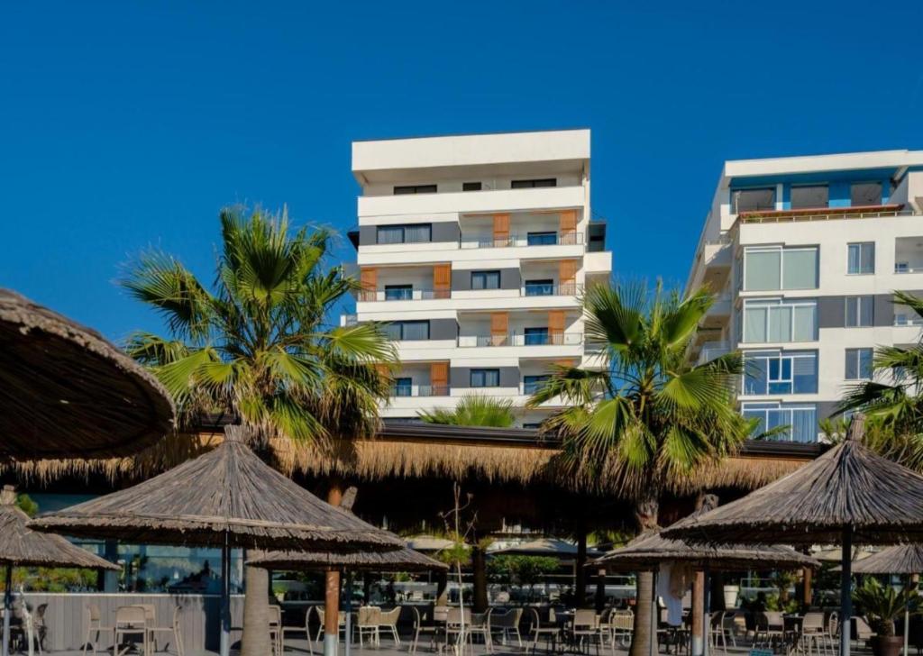 un hôtel avec des tables et des parasols devant un bâtiment dans l'établissement Flor de mar qerret, à Golem