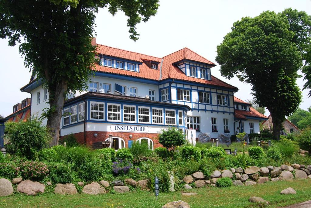 un grand bâtiment blanc avec un toit rouge dans l'établissement Ferienwohnung auf Hiddensee im Ort Kloster, à Kloster