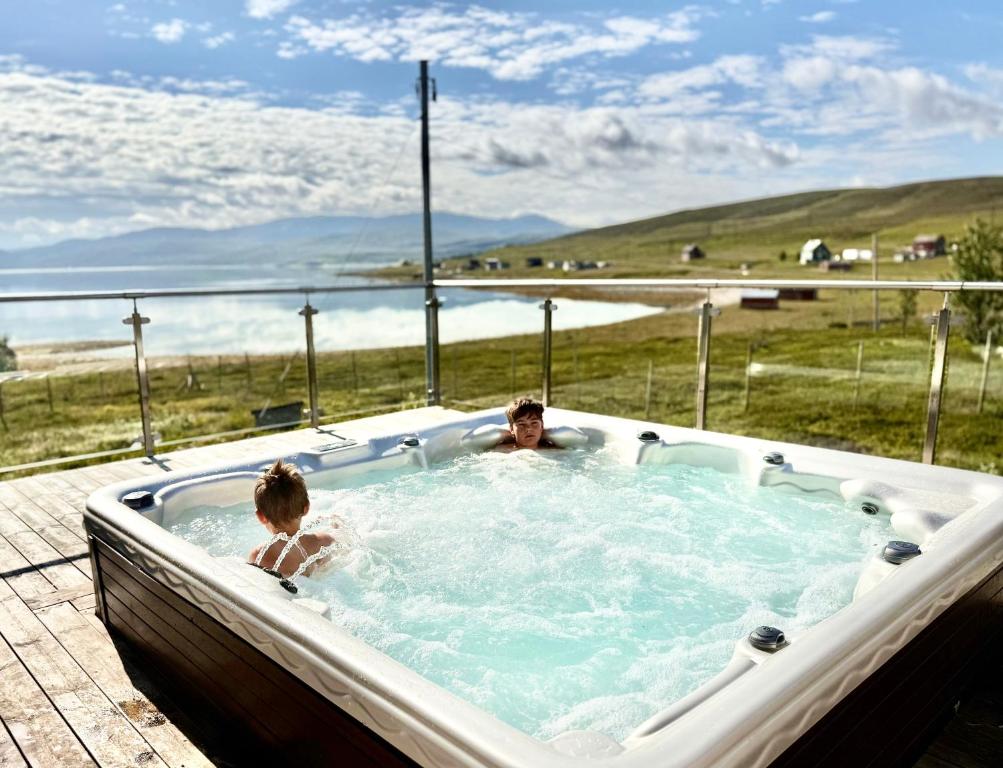two people in a jacuzzi tub with a view at Jacuzzi, fjord view & northern lights - close to Hammerfest & North Cape in Hammerfest