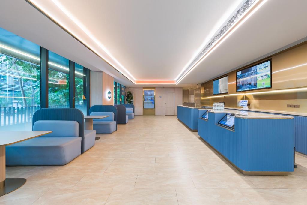 a lobby of a hospital with blue chairs and tables at Hanting Hotel Beijing Jiaotong University in Beijing