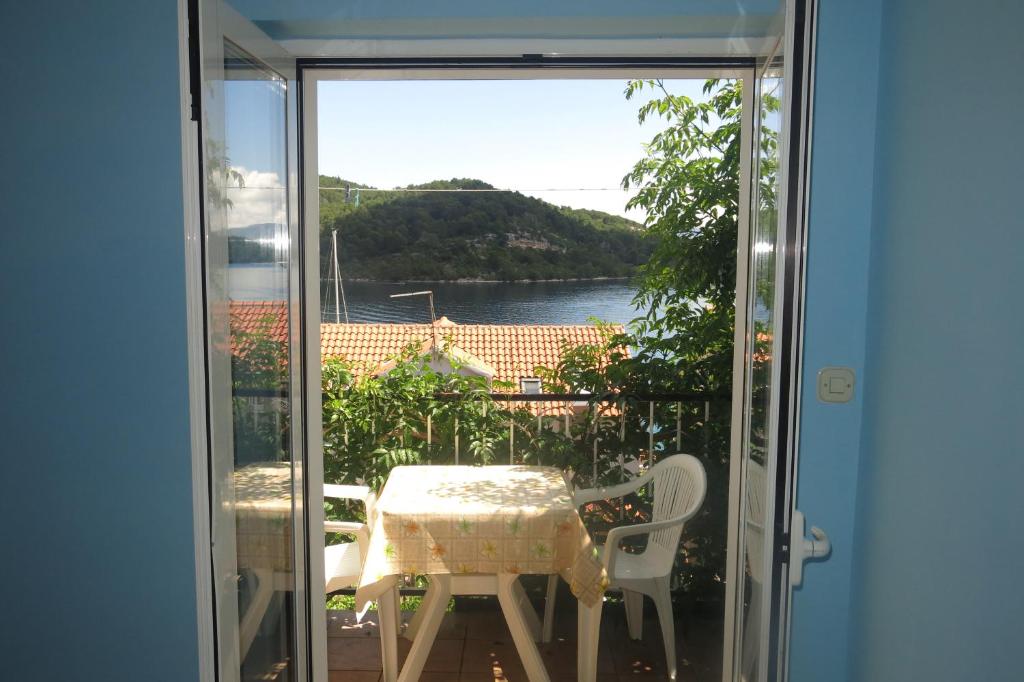 einen Balkon mit Blick auf einen Tisch und Stühle in der Unterkunft Apartments Dabelić in Polače