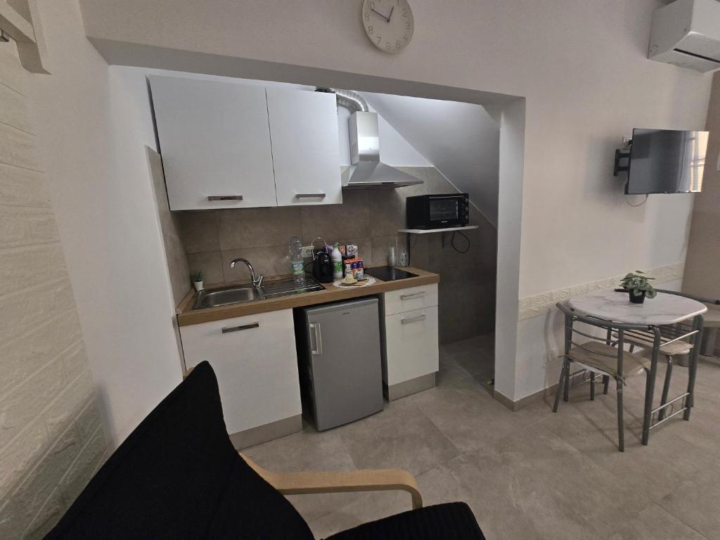 a small kitchen with a sink and a table at Maclas Apartment -Vasto Centro Storico- in Vasto