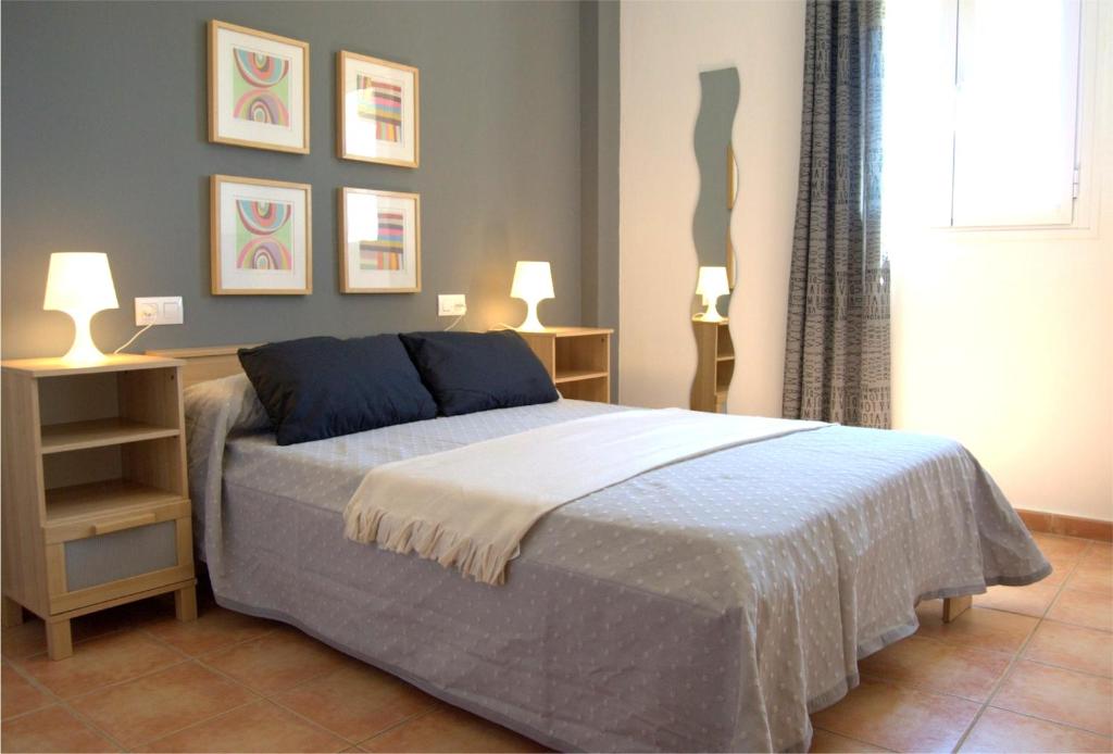 una camera da letto con un letto con due lampade sopra di Apartamentos BeSlow La Antilla a La Antilla