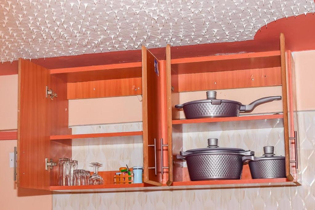a kitchen shelf with pots and pans on it at Blissful homes in Ruiru
