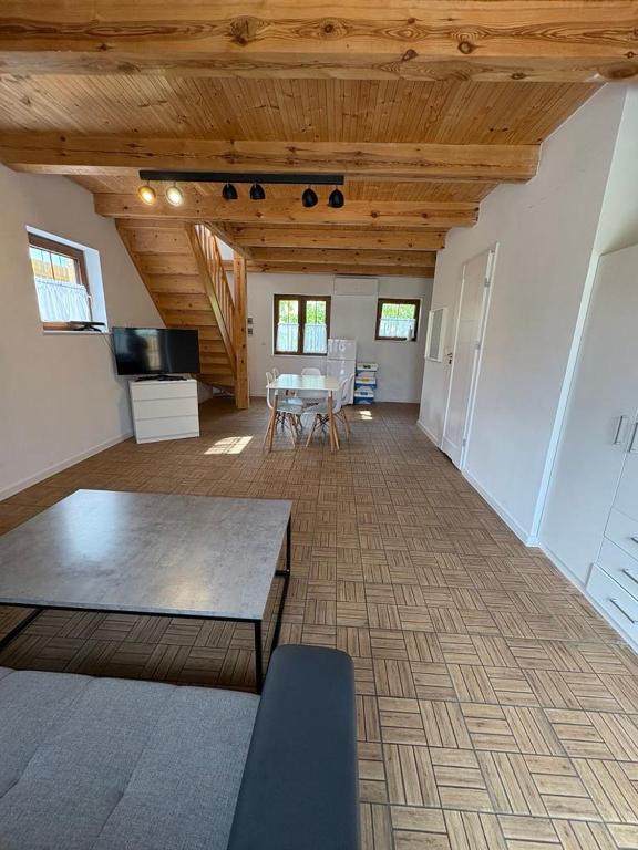 a large living room with a table and a kitchen at Domek Mikołajki in Mikołajki