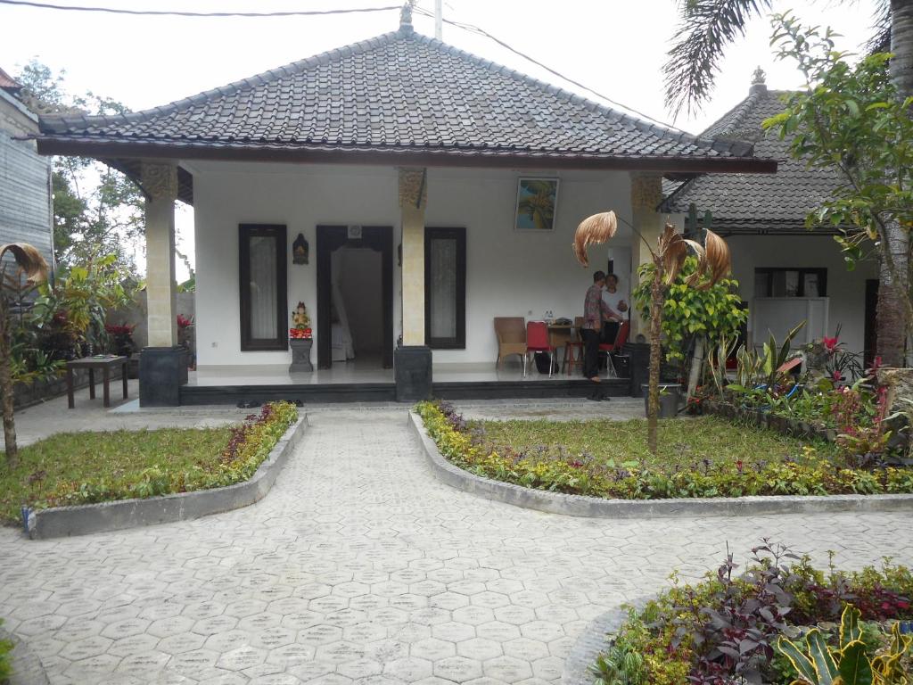 a house with a patio with a table and people in it at Manik Villa Besakih in Besakih