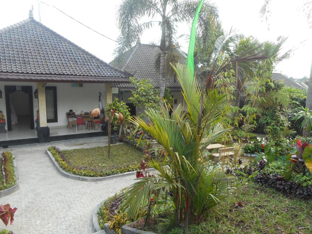 a garden with palm trees and a house at Manik Villa Besakih in Besakih