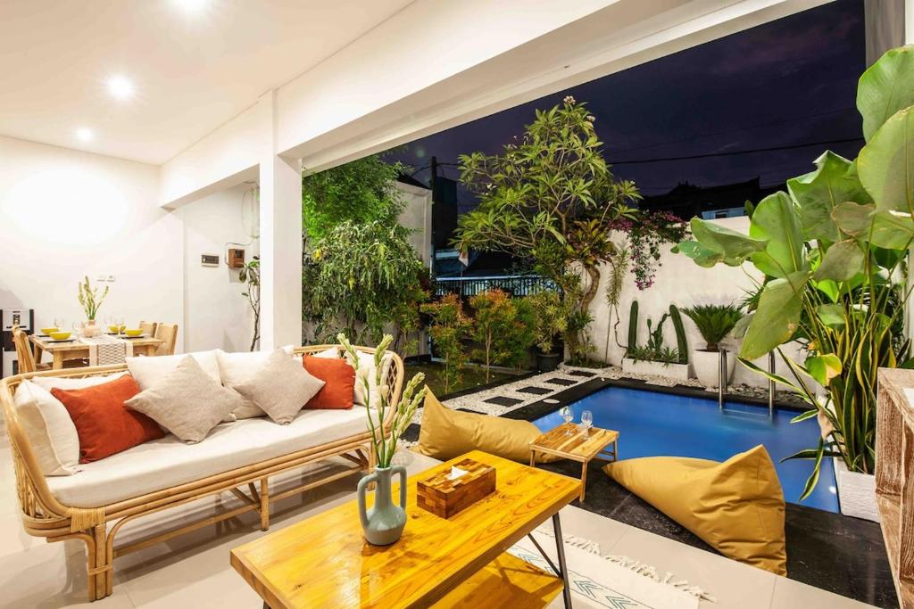 un salon avec un canapé et quelques plantes dans l'établissement Maha Villas, à Canggu