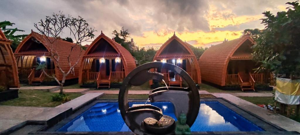 a resort with a fountain in front of a pool at Nusa Dua Huts Pondok Gajah Para in Nusa Dua