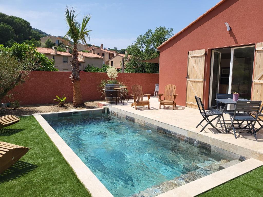 a swimming pool in a yard with a table and chairs at Villa cosy avec piscine à Collioure in Collioure