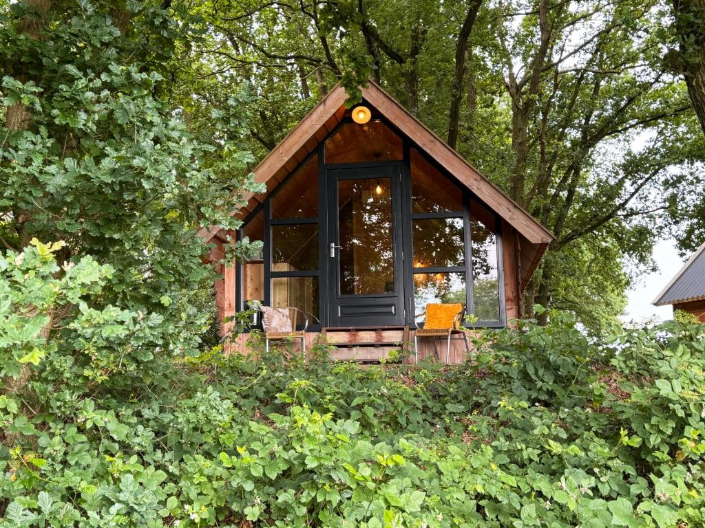a small cabin in the middle of a forest at De Schutkooi - Tiny Houses in Vortum-Mullem