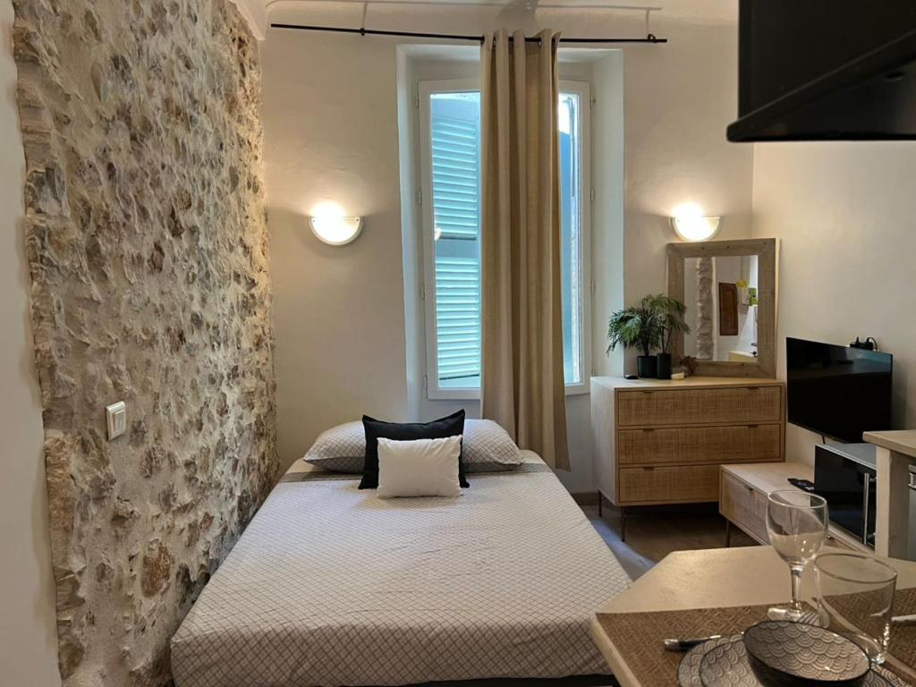 a bedroom with a bed in a room with a window at Studio dans le vieil Antibes in Antibes