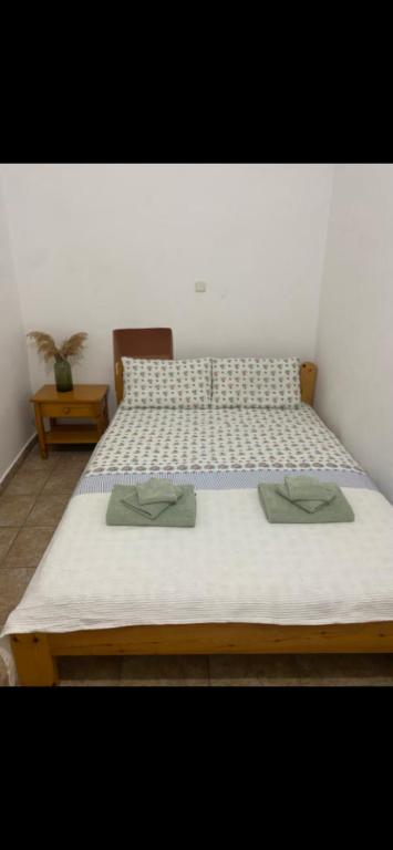 a large bed with two green pillows on it at Mimi's House 1 in Chios