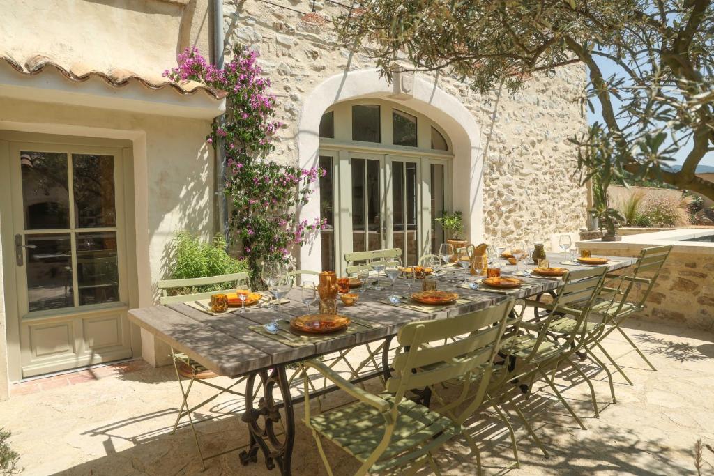 a long table in front of a house with food on it at Le Clos de la Croix du Serre in Mirabel-aux-Baronnies