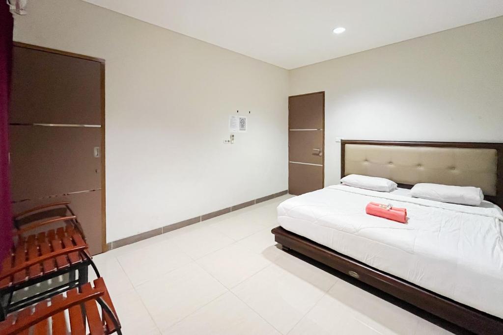 Un dormitorio con una cama con una maleta roja. en Urbanview Hotel Wongso Pangkal Pinang, en Pangkalpinang