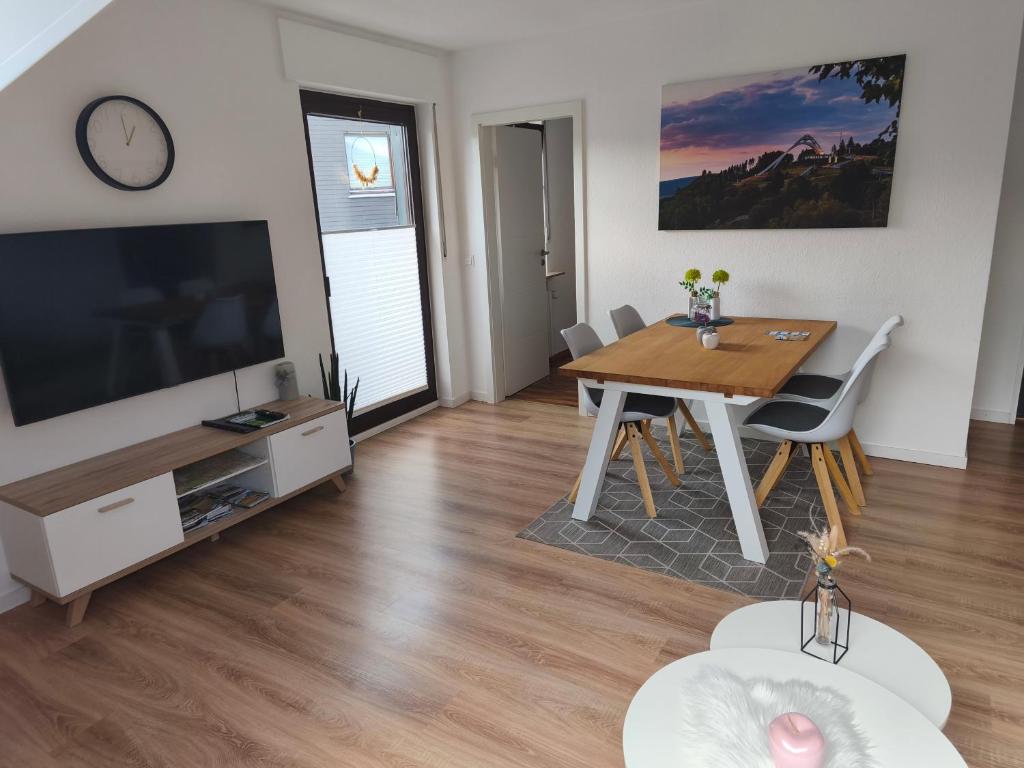 ein Wohnzimmer mit einem Esstisch und einem TV in der Unterkunft Winterberg Centrum mit privaten Ski Keller in Winterberg