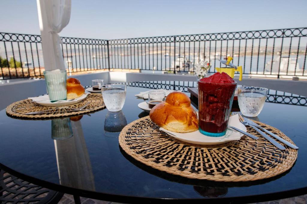 a table with two plates of food and a drink at A Casa da Nelly Augusta in Augusta