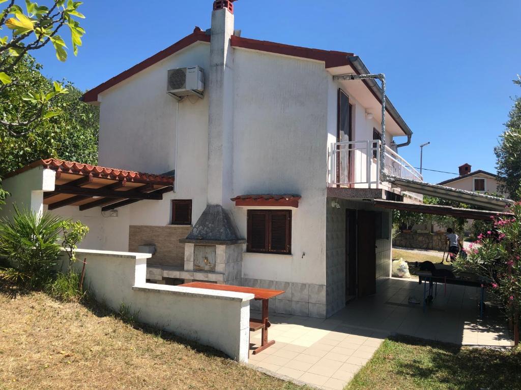 a white house with a porch and a balcony at Hiša Seča Sunset in Portorož