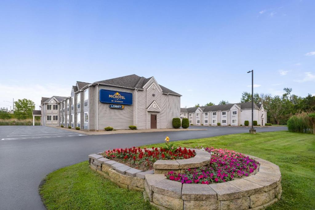 un hotel con una cama de flores frente a un edificio en Microtel Inn by Wyndham - Albany Airport, en Latham