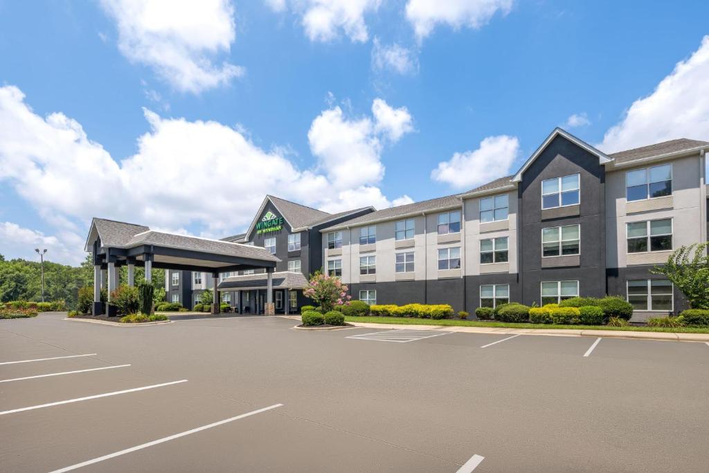 an exterior view of a hotel with a parking lot at Wingate by Wyndham Matthews - Charlotte in Matthews