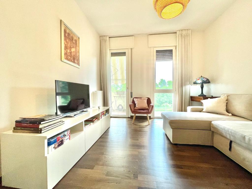 Una sala de estar con un sofá y un televisor. en A casa di cocco, en Padua