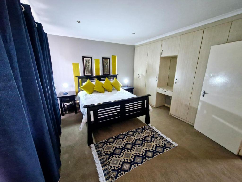 a bedroom with a bed with yellow pillows at Rockhound in Boksburg