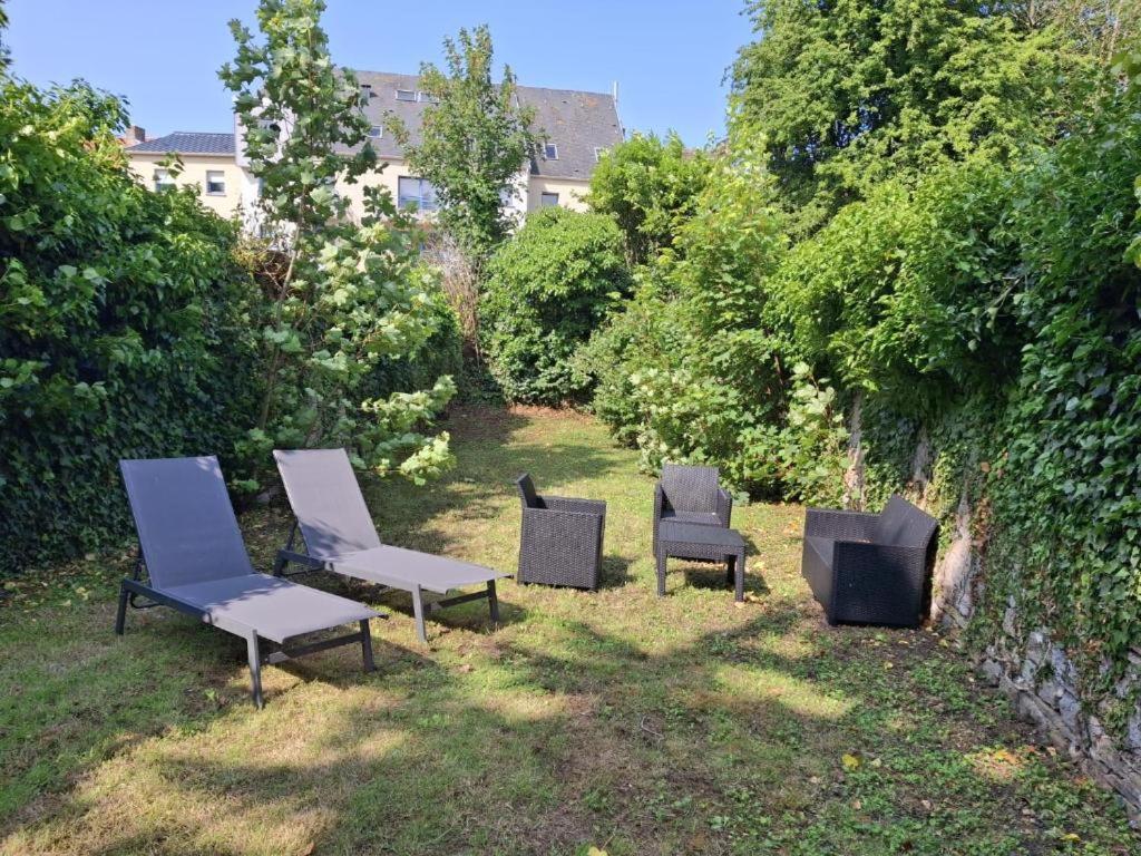 a group of chairs sitting in the grass at 35 m2 charmant plus 30 M2 de terrasse Accès jardin SPA in Boulogne-sur-Mer
