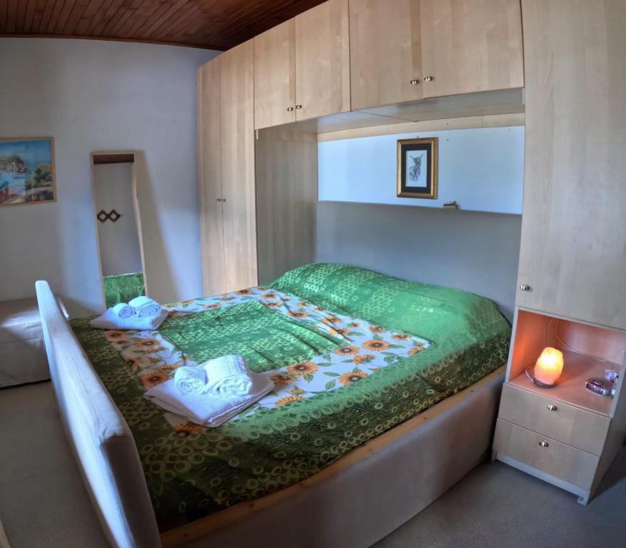 una camera da letto con un letto con un piumone verde di Rium Mare & Monti a Pieve di Cadore