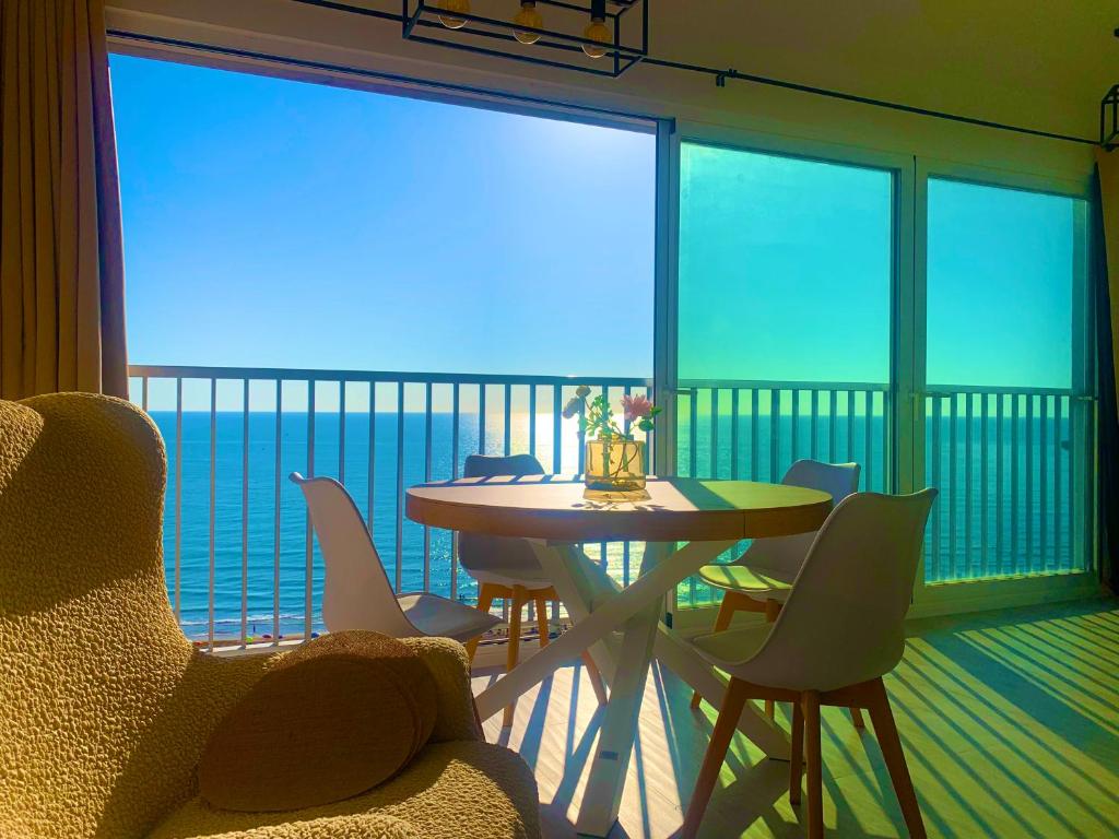 ein Wohnzimmer mit Tisch und Stühlen und einem Balkon in der Unterkunft Apto LUXURY BONAIRE in Puerto de Gandía