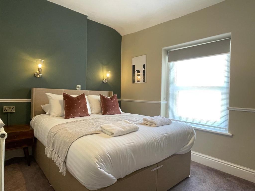 a bedroom with a large bed and a window at Wedgwood Hotel, Seascape Room in Llandudno