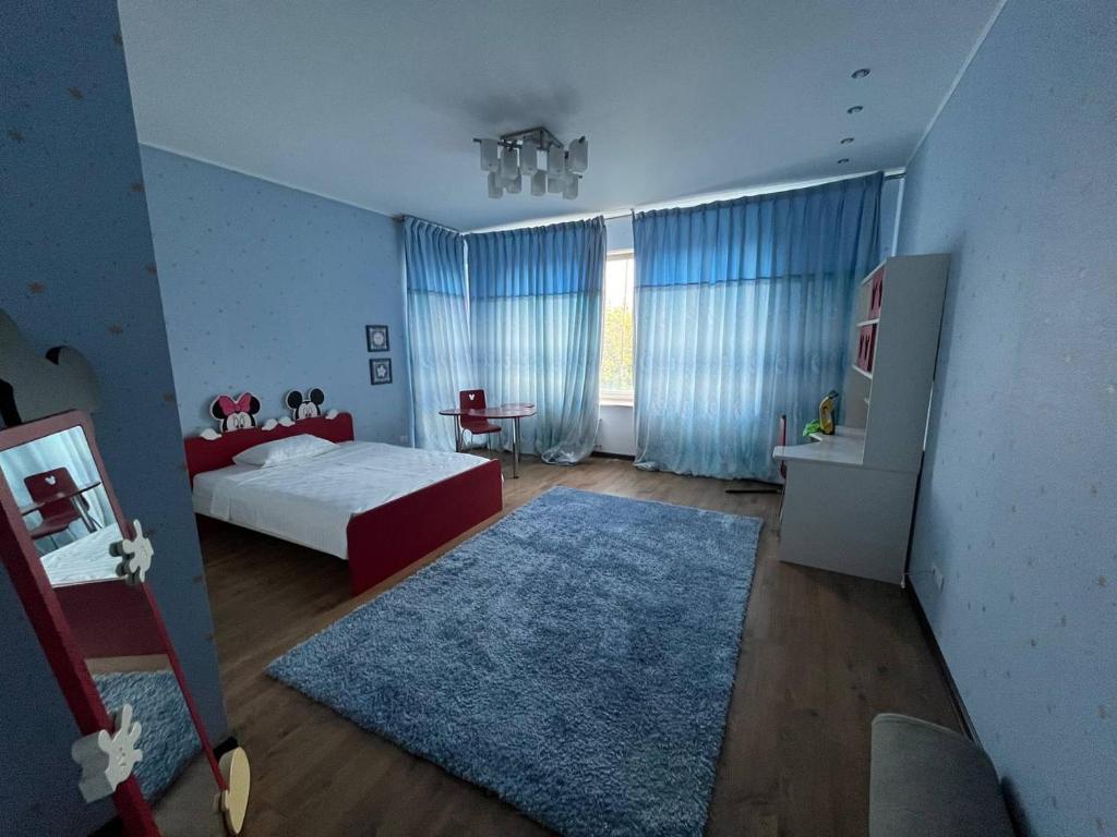 Un dormitorio con una cama y una alfombra azul. en Fontan House, en Odessa