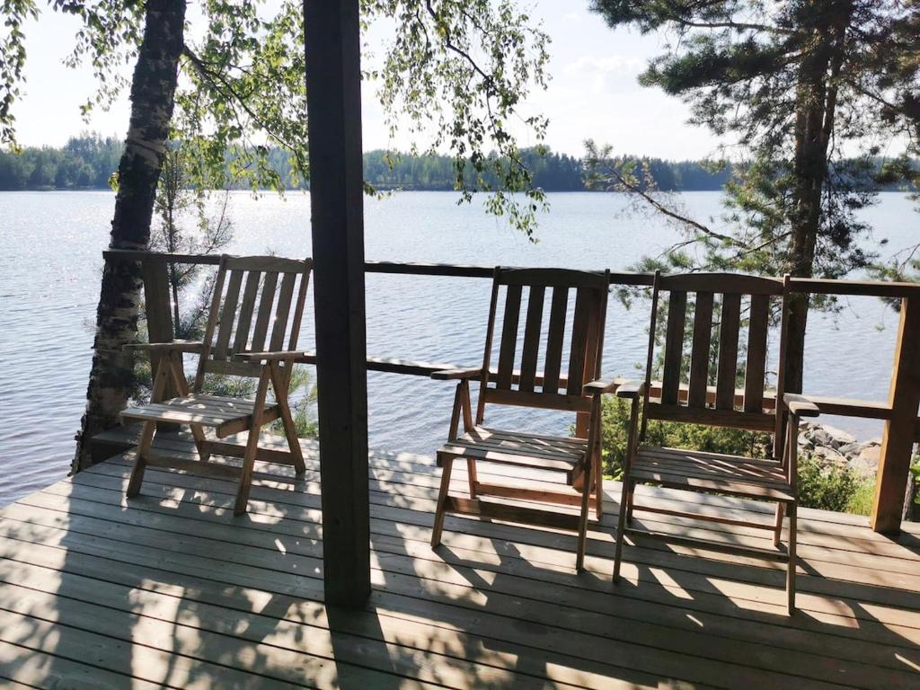 two chairs sitting on a porch overlooking a lake at Upea miljöö Saimaan rannalla in Joensuu
