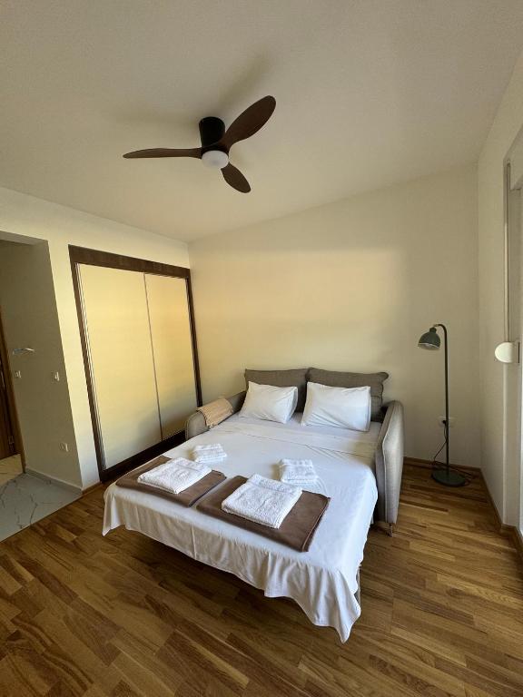 a bedroom with a large bed with a ceiling fan at Stylish Studio IVSOLE in Budva