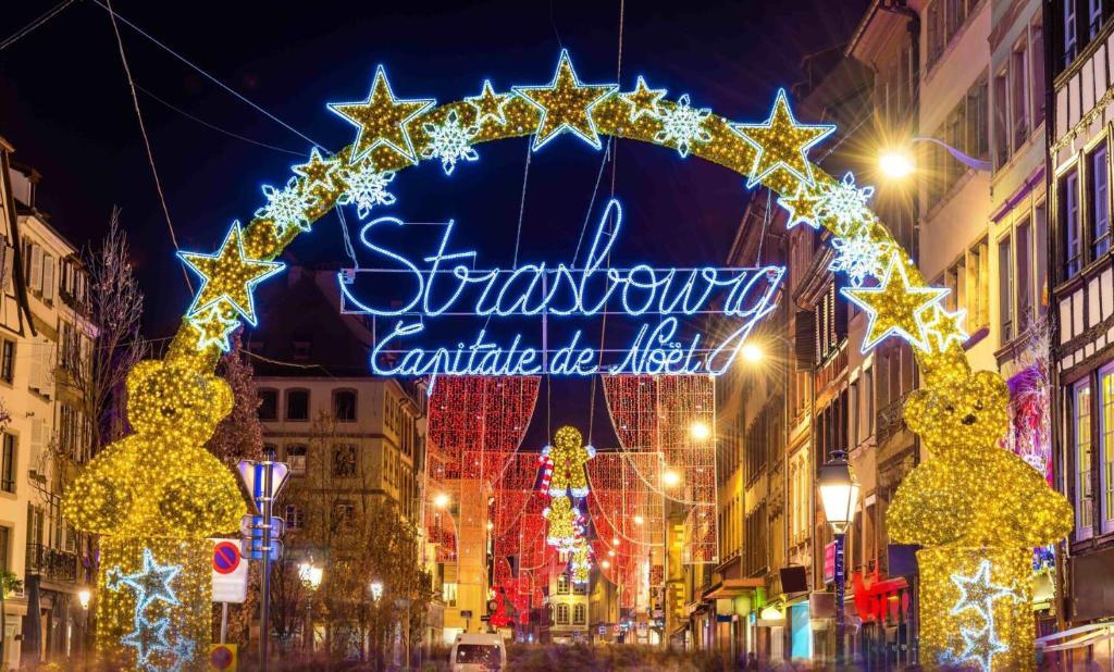 a city street with a christmas sign and lights at La Meinau in Strasbourg
