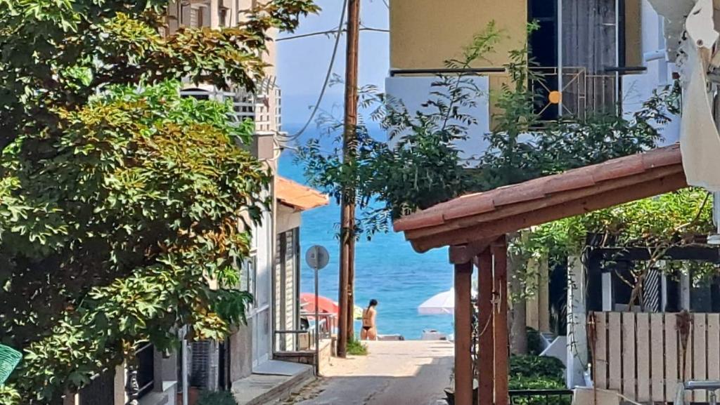 een straat met gebouwen en de oceaan op de achtergrond bij Paulos Apartment in Pefkochori