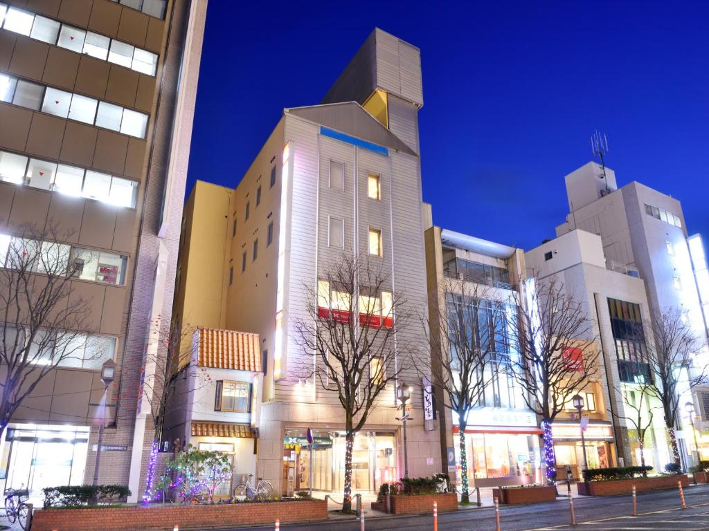 um grupo de edifícios em uma cidade à noite em Morioka City Hotel em Morioka