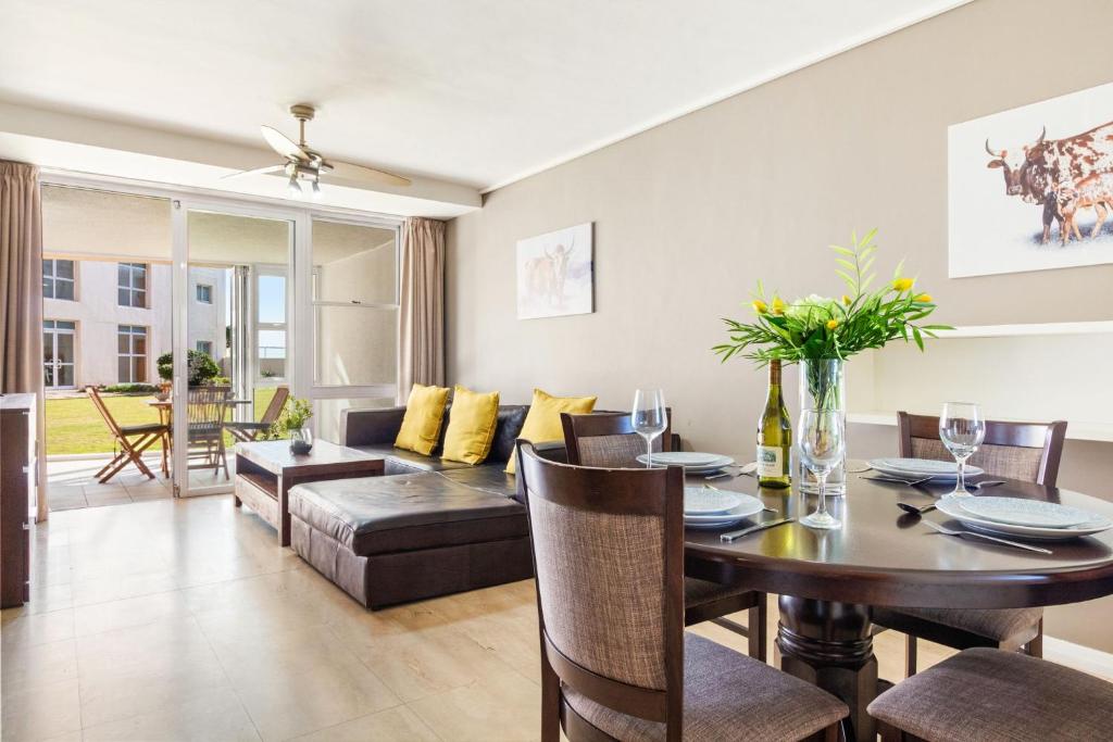 a living room with a table and a couch at Lagoon Beach 29A by Host Agents in Cape Town