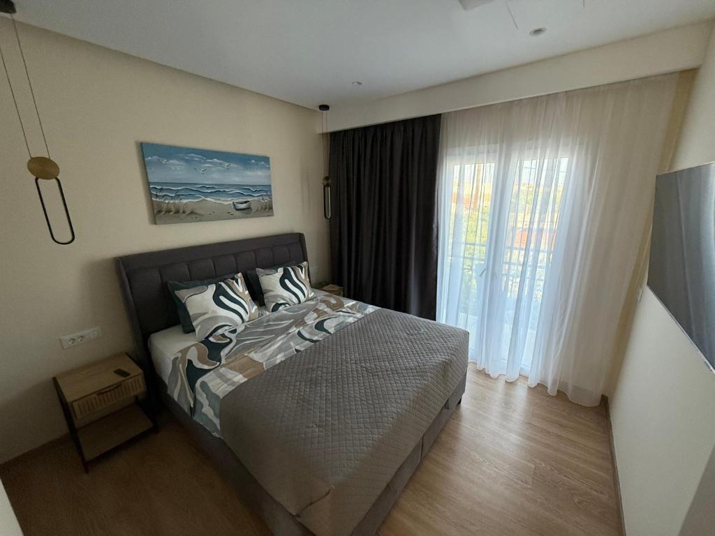 a bedroom with a bed and a large window at Azure Ionian in Agios Georgios