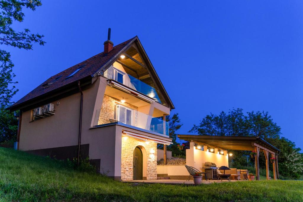 a house on a hill with lights on it at KICIKLA Fire & Wine in Nagybakónak