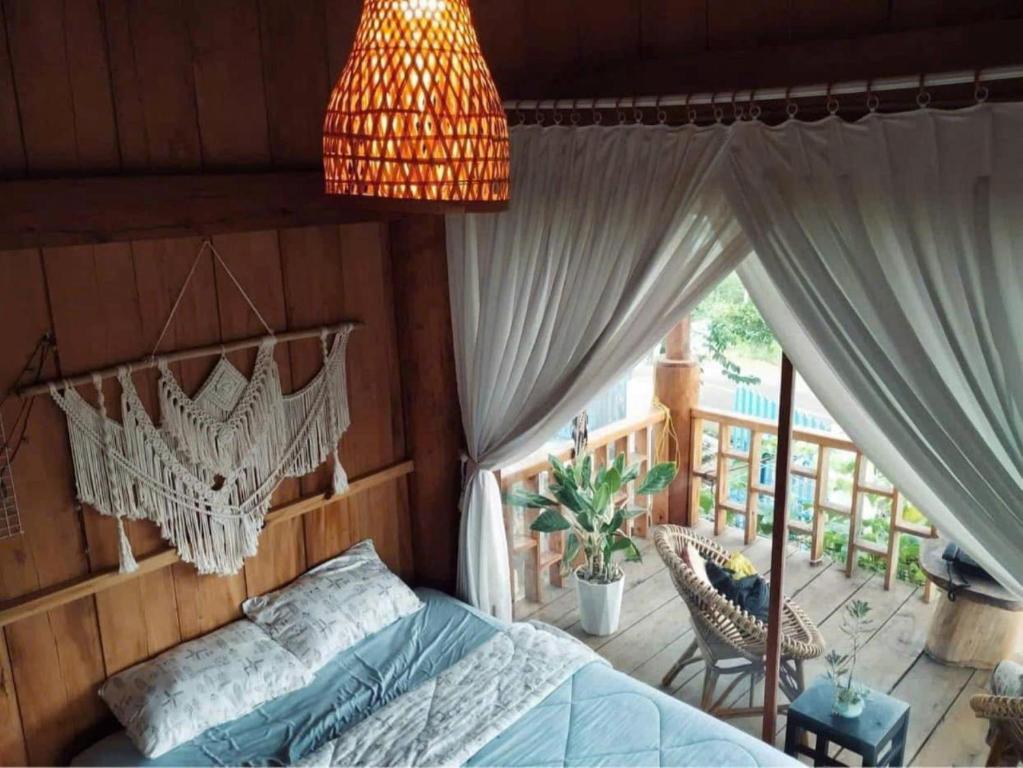 a bedroom with a bed and a chandelier at Cô Ba Homestay Măng Đen in Kon Von Kla