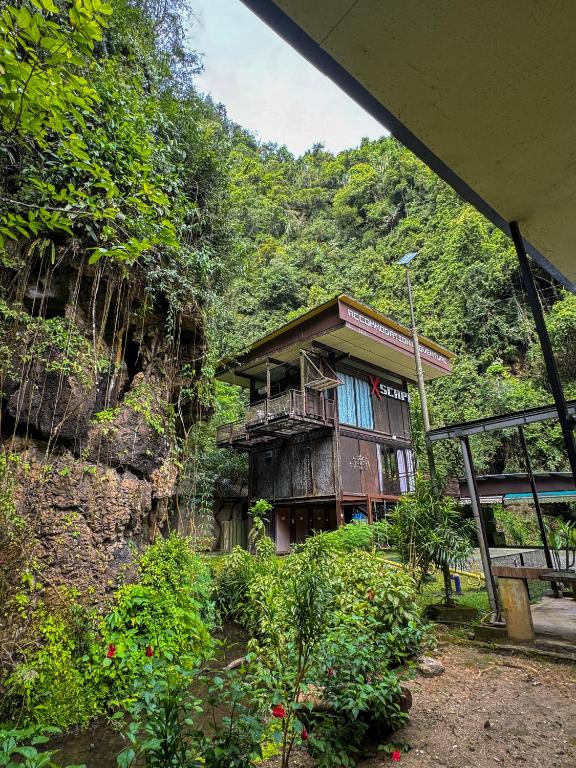 a building on a hill with trees and bushes at Xscape Tambun in Ipoh