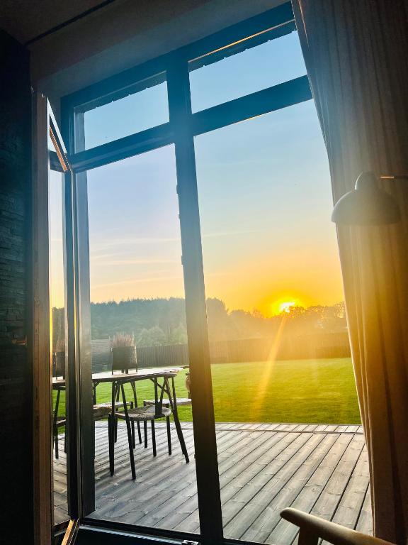 a view of a deck with a table and a sunset at Modern Villa By The Sea in Palanga