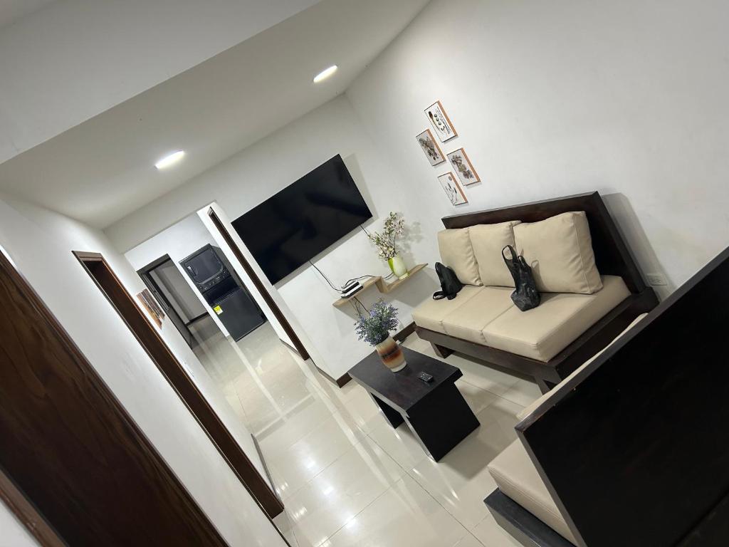 Una sala de estar con un sofá y un televisor. en 9 Bedrooms house, en Medellín