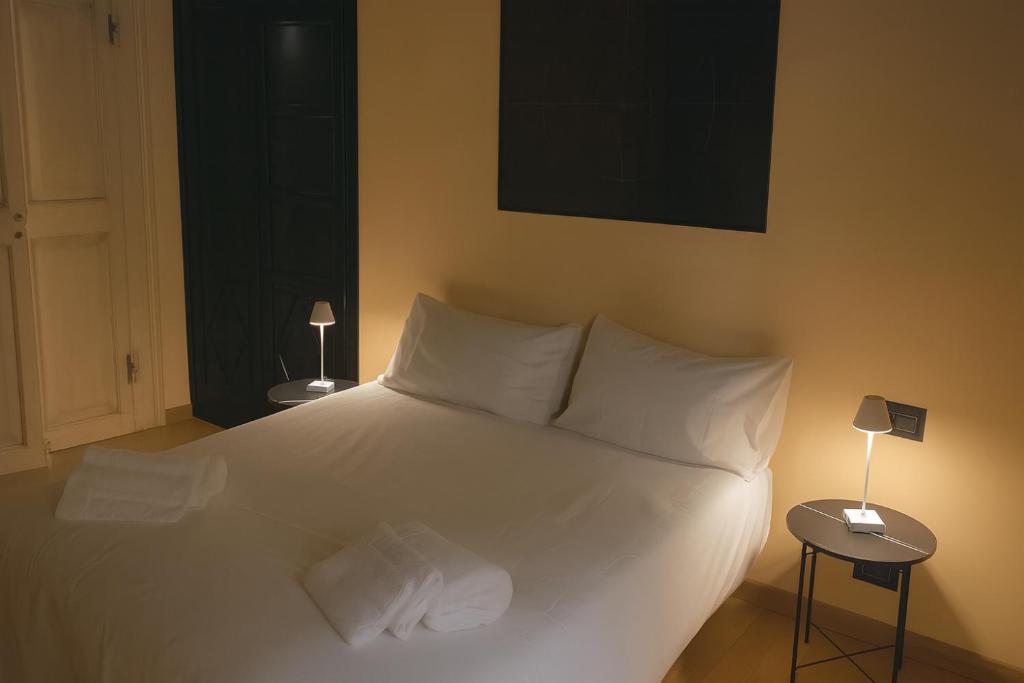 une chambre avec un grand lit blanc avec deux lampes dans l'établissement Borgolungo Apartament Viterbo, à Viterbe